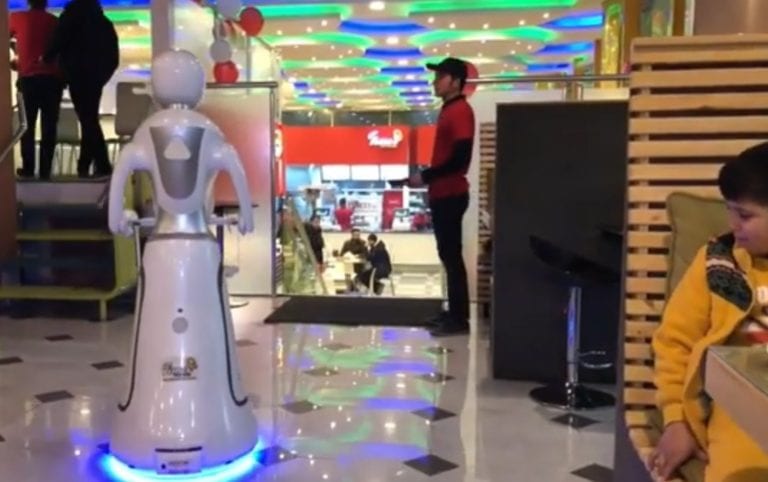 Un robot realizat sub forma unei chelnerițe poliglote servește pizza și cartofi prăjiți într-un restaurant